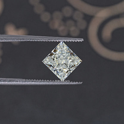 Princess-cut moissanite loose stone, on tweezers; close-up of faceted center.