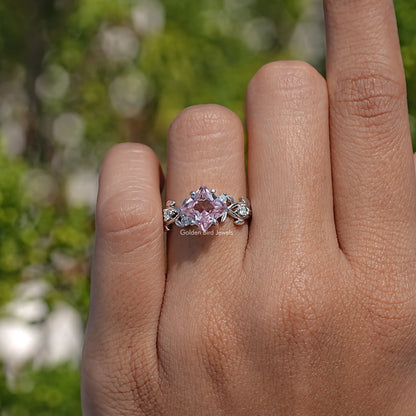 Lab gemstone leaf-style engagement ring with pink center stone and silver leaf side settings
