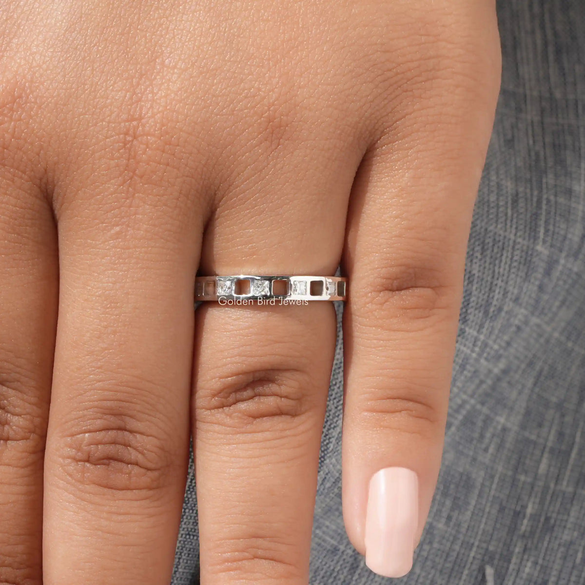 925 sterling silver eternity ring with princess-cut moissanite stones, viewed from front on finger