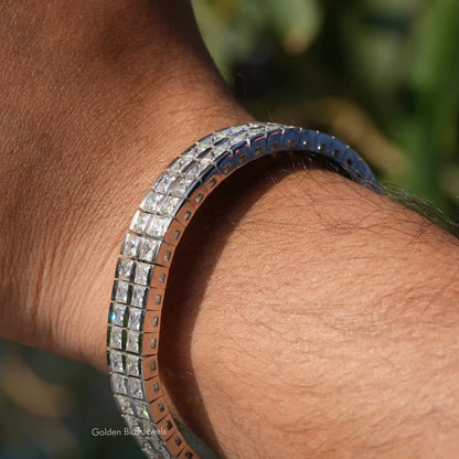 Men's princess-cut moissanite tennis bracelet on wrist, silver-toned link rows