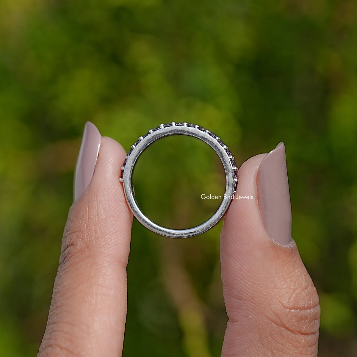 Silver amethyst eternity band ring with round purple gemstones around the band