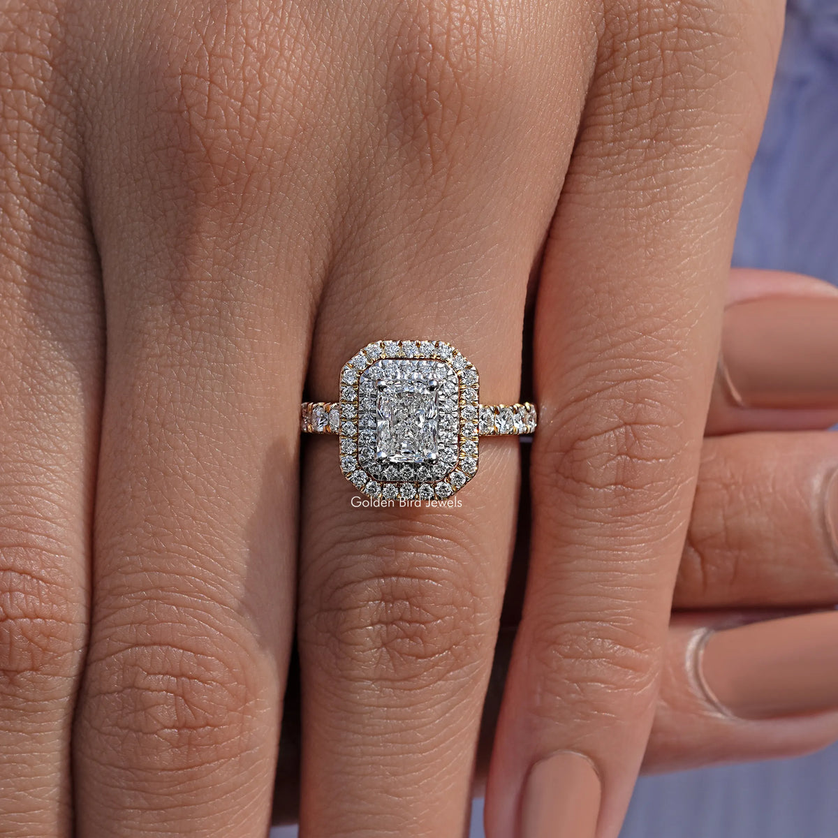 Silver-toned double halo engagement ring with rectangular radiant-cut center and side stones