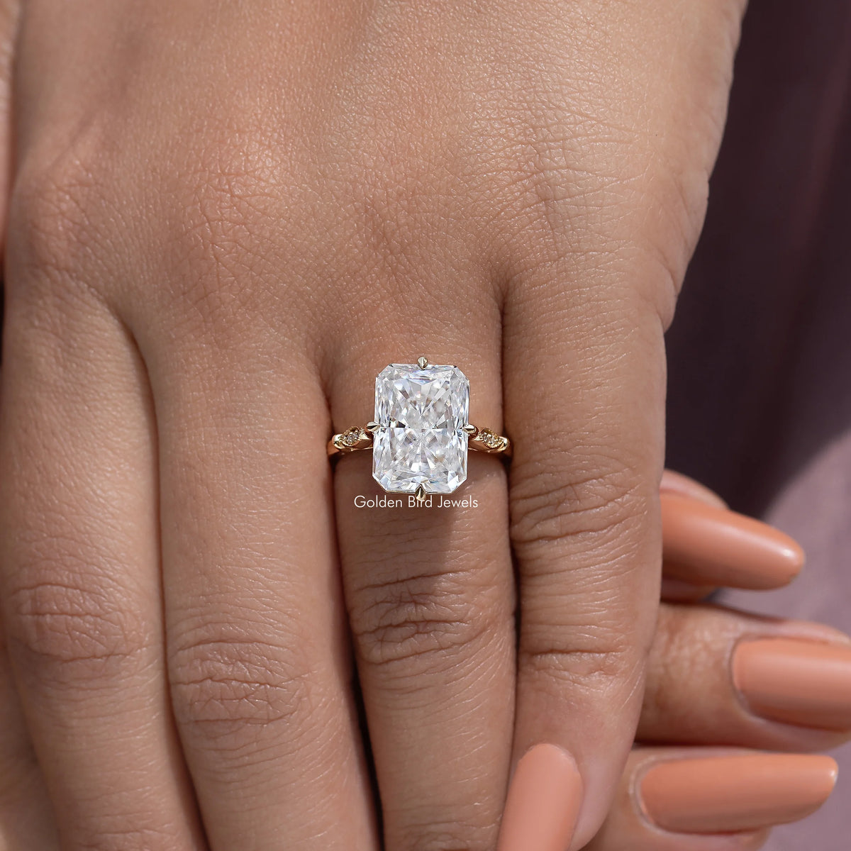 Engagement ring with large rectangular-cut center stone and gold-toned side accents