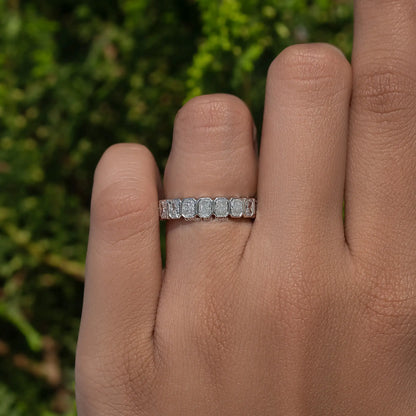 Silver eternity band ring with small bezel-set stones across the top of finger