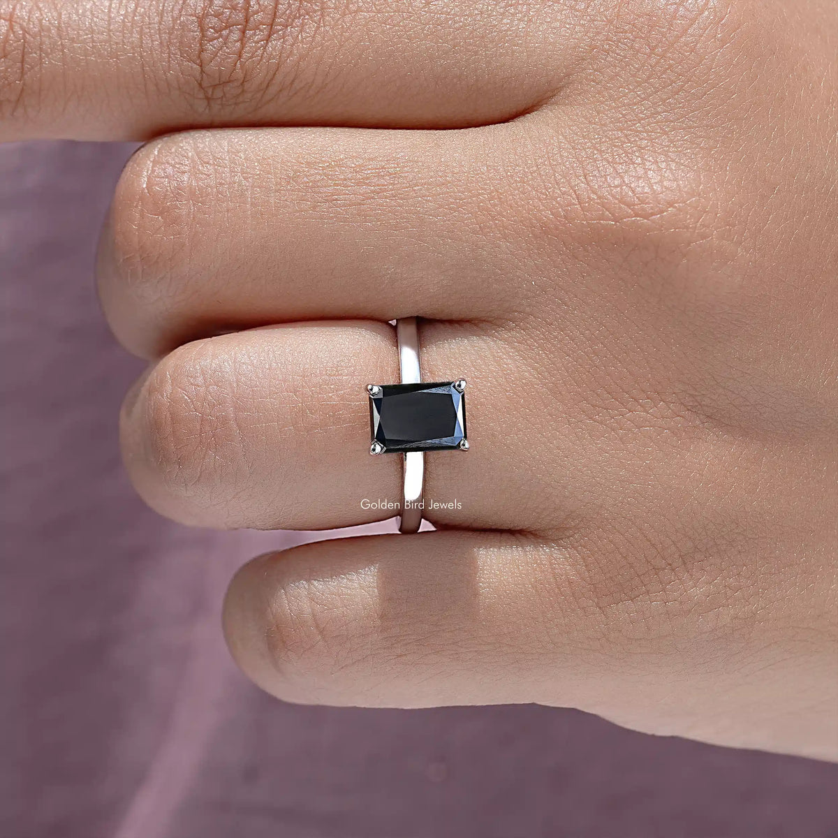 Close-up silver ring band featuring a square black moissanite center stone