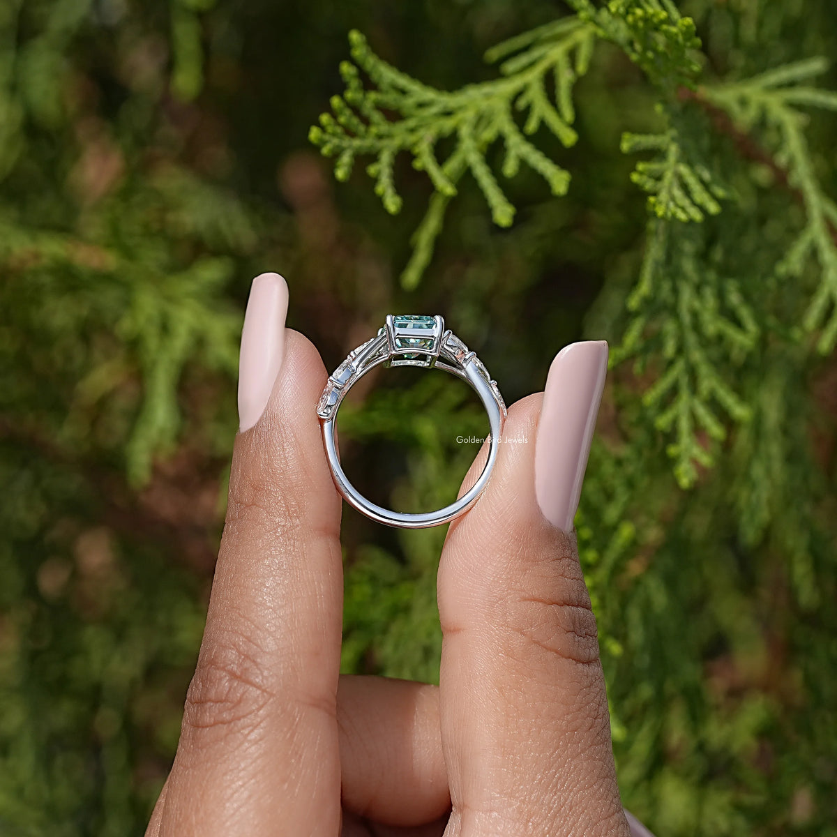 Sterling silver ring viewed from front with square teal center and halo detail