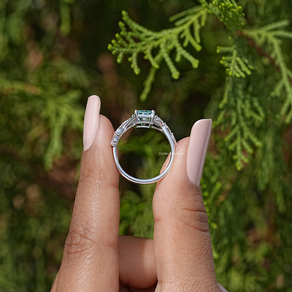 Sterling silver ring viewed from front with square teal center and halo detail