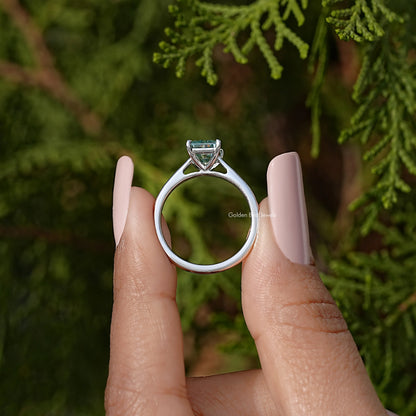 Sterling silver solitaire ring with emerald-cut blue-green moissanite, front view.