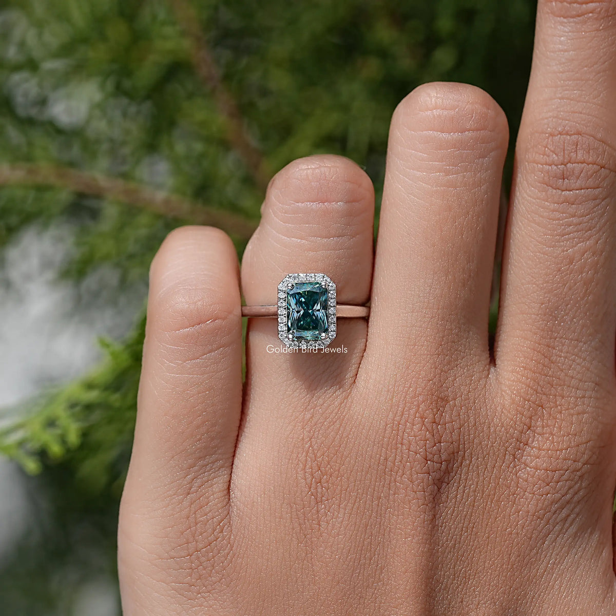 Sterling silver emerald-cut blue moissanite halo wedding ring close-up