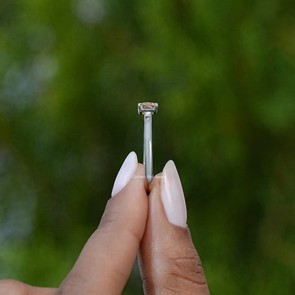 Yellow emerald-cut solitaire ring on silver-tone band, side profile
