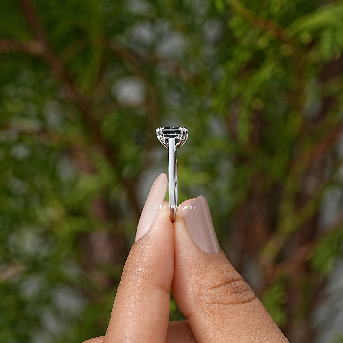 Silver solitaire ring with black gemstone, tall prongs visible from side