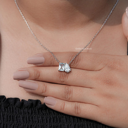 Two-stone toi et moi pendant on delicate silver chain, close-up with hand resting