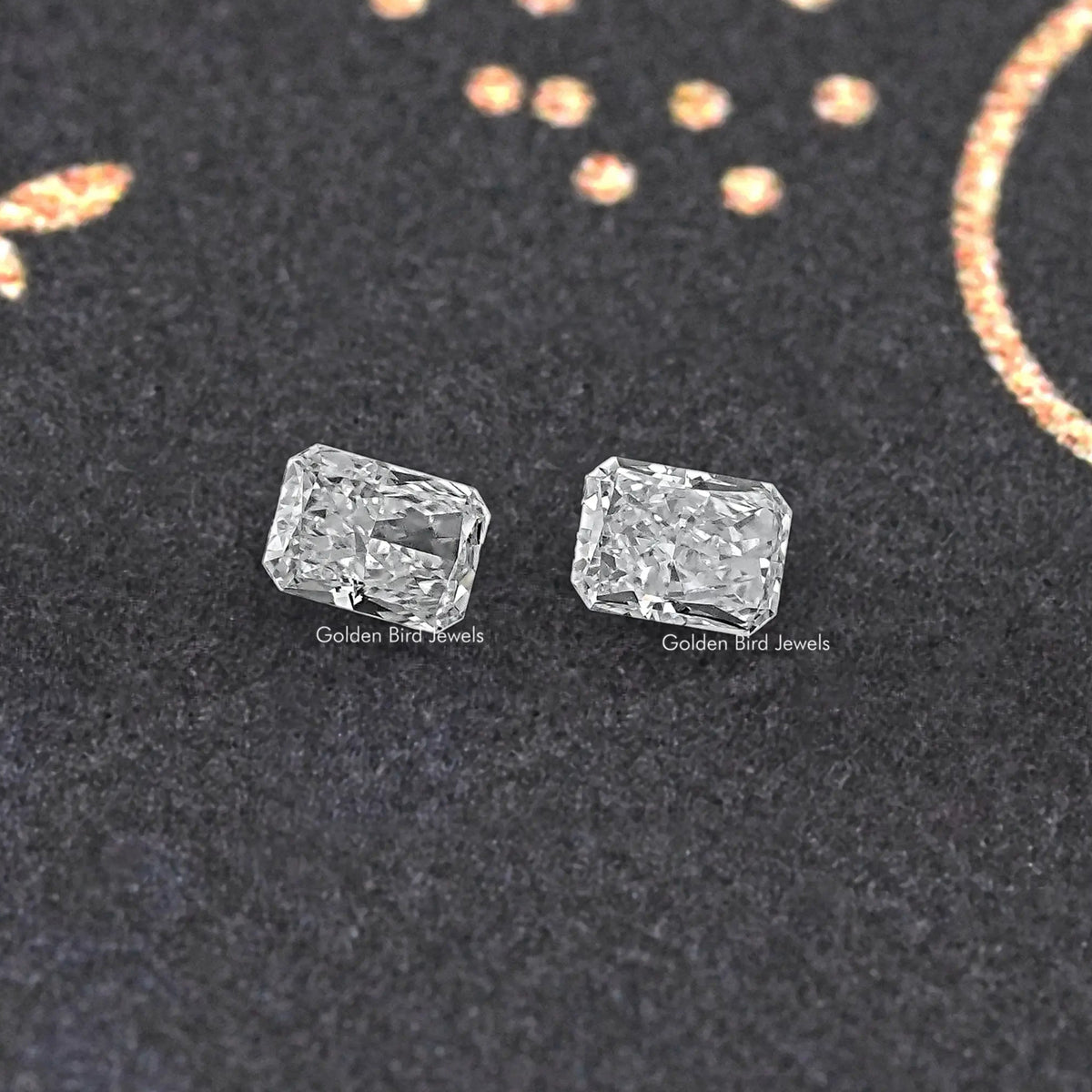 Radiant-cut loose diamond pair, matching clear rectangular stones shown from front.
