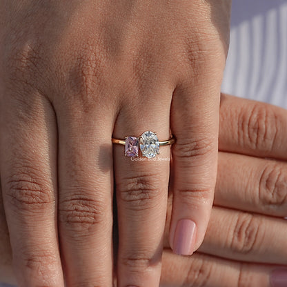 Two-stone oval diamond and pink gemstone ring on hand, rose gold-tone band