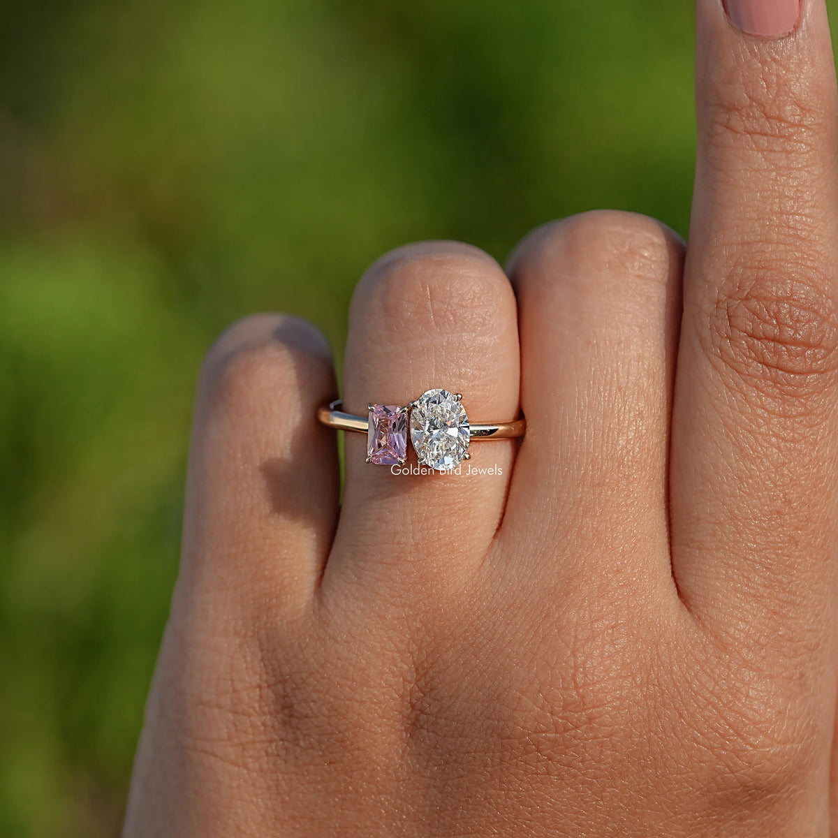 Oval center diamond with square pink gemstone accents on rose gold-tone ring
