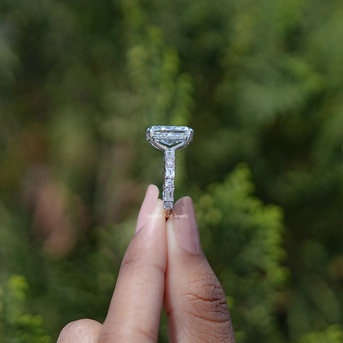 Prong-set radiant lab diamond ring held between fingers