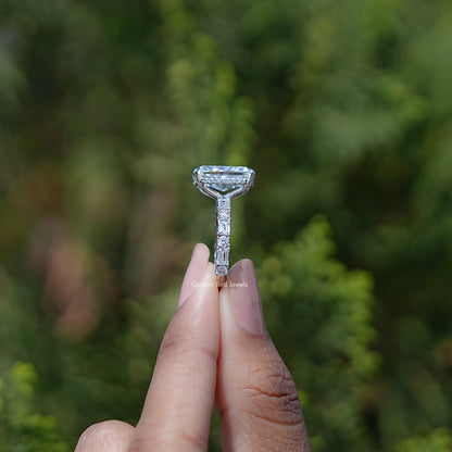 Prong-set radiant lab diamond ring held between fingers