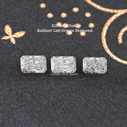 Three radiant-cut loose lab diamonds in a row, clear white stones on dark cloth