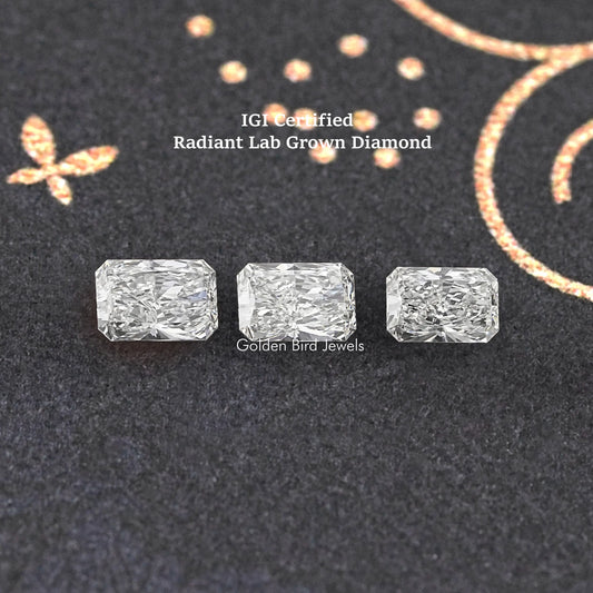 Three radiant-cut loose lab diamonds in a row, clear white stones on dark cloth