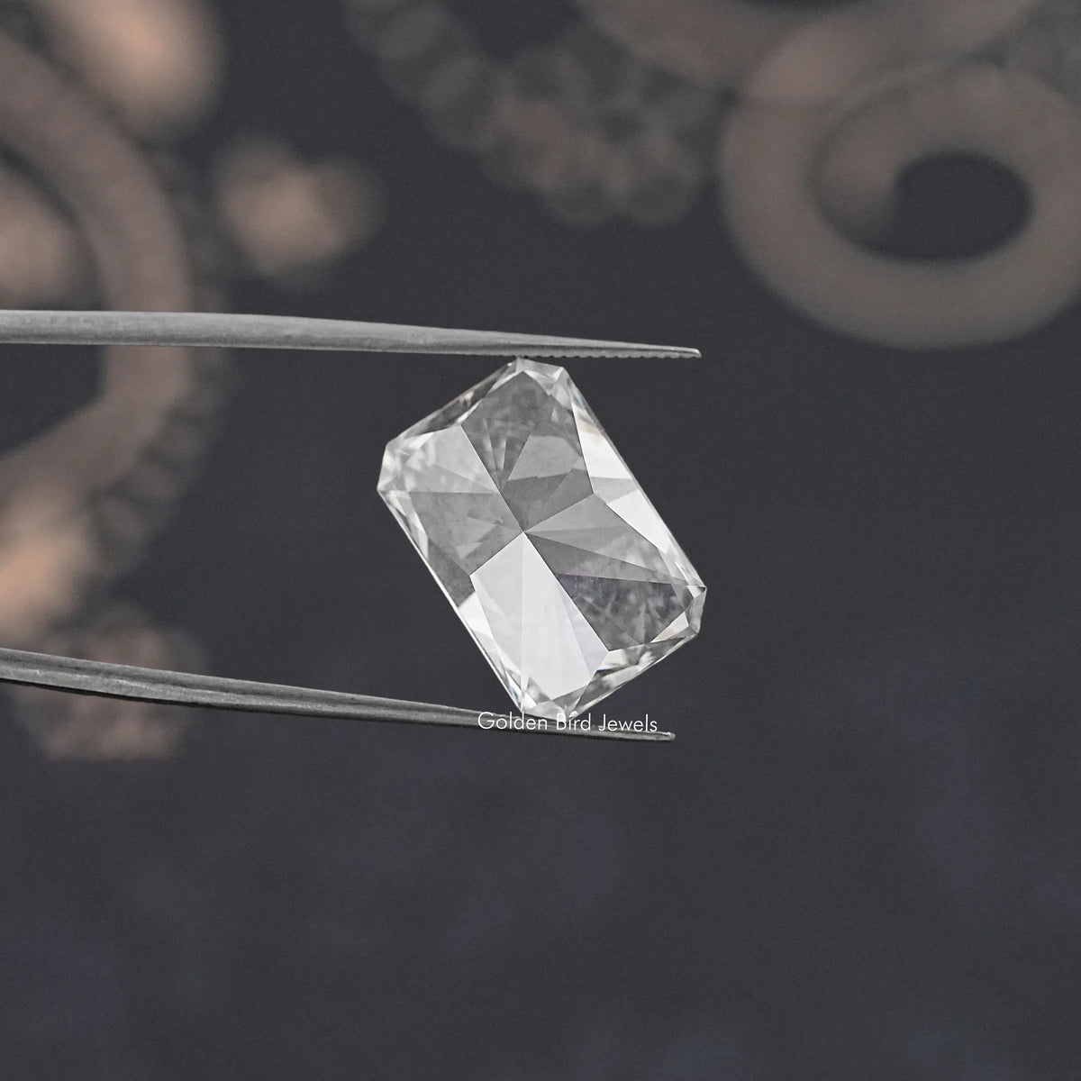 Radiant-cut loose lab diamond held in tweezers, clear white angled view
