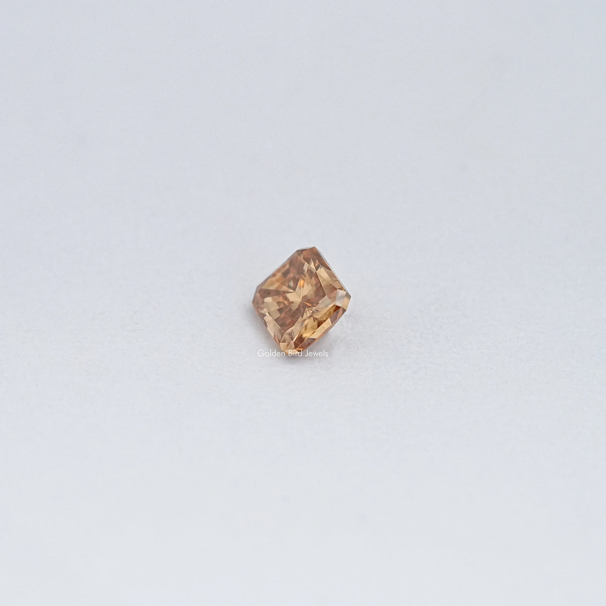 Small champagne moissanite loose stone, emerald-cut with warm amber facets