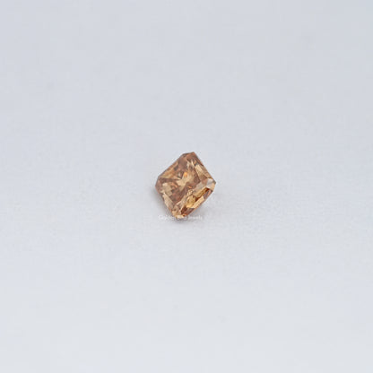 Small champagne moissanite loose stone, emerald-cut with warm amber facets