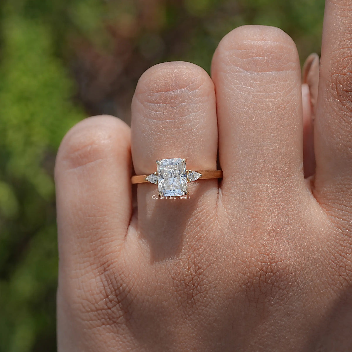 In finger view of Radiant Cut Three Stone Engagement Ring