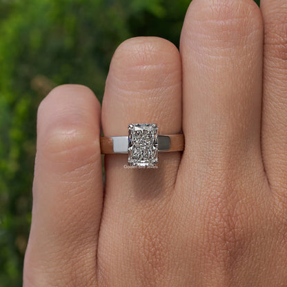 Square-cut diamond ring centered on a hand, silver band and prongs