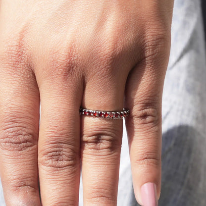 In finger front view of Red Garnet Round Gemstone Half Eternity Band in unique shape