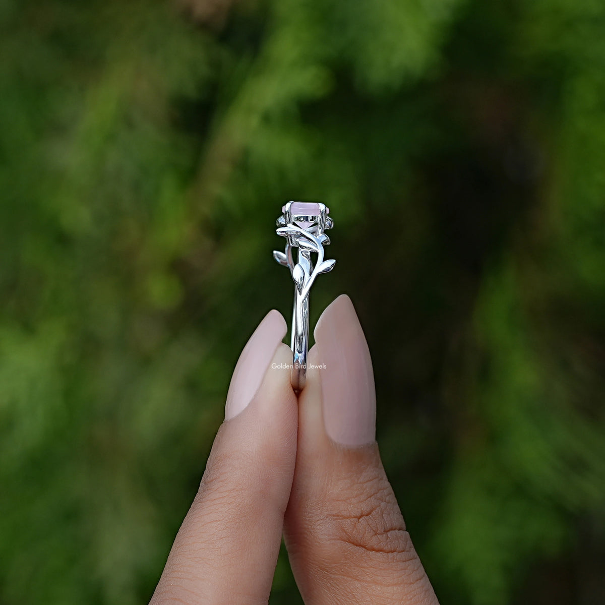 Rose quartz round gemstone leaf-style ring with silver band on finger