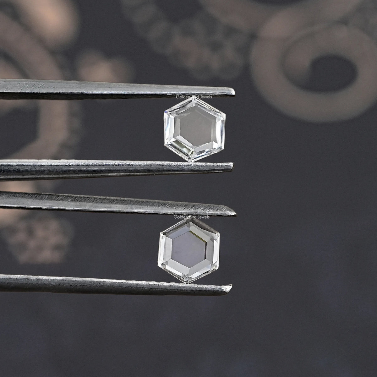 Tweezers holding a clear hexagon lab-grown diamond, faceted loose stone