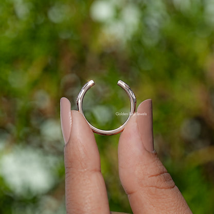 Open cuff leaf design ring with curved open front held between fingers