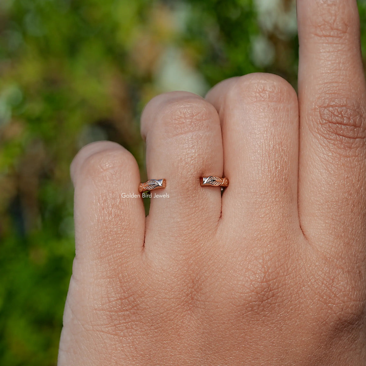 Open cuff wedding band with small leaf motif centered on open palm