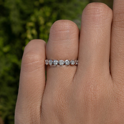 Silver-toned round bezel lab diamond wedding band with five round bezel stones, front view