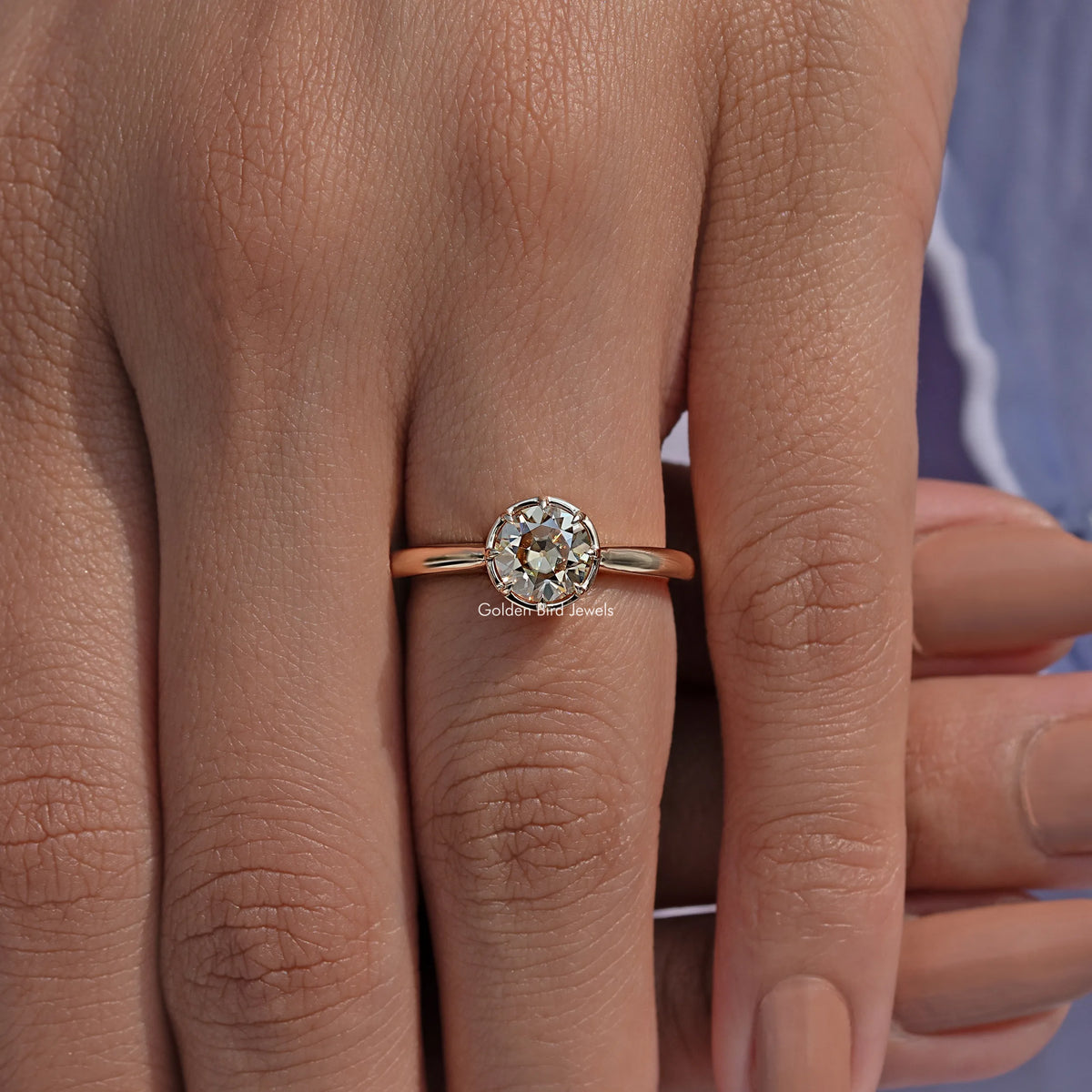 Round moissanite engagement ring with gold-tone band and prong-set round stone