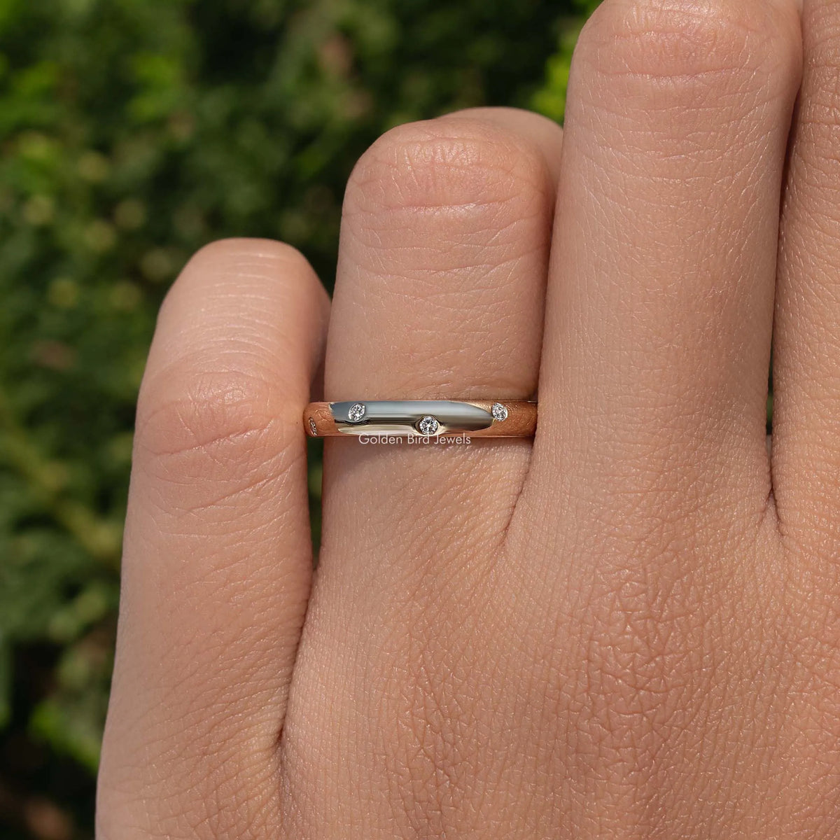 Flush-set diamond eternity band ring on finger, close-up side view