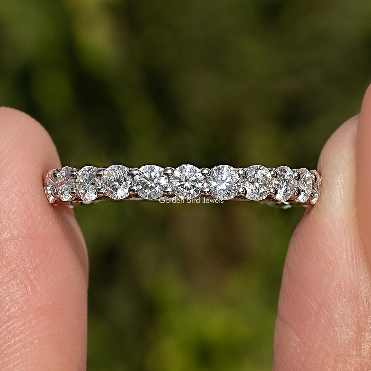 Round moissanite eternity wedding band in 925 sterling silver, side view of stones