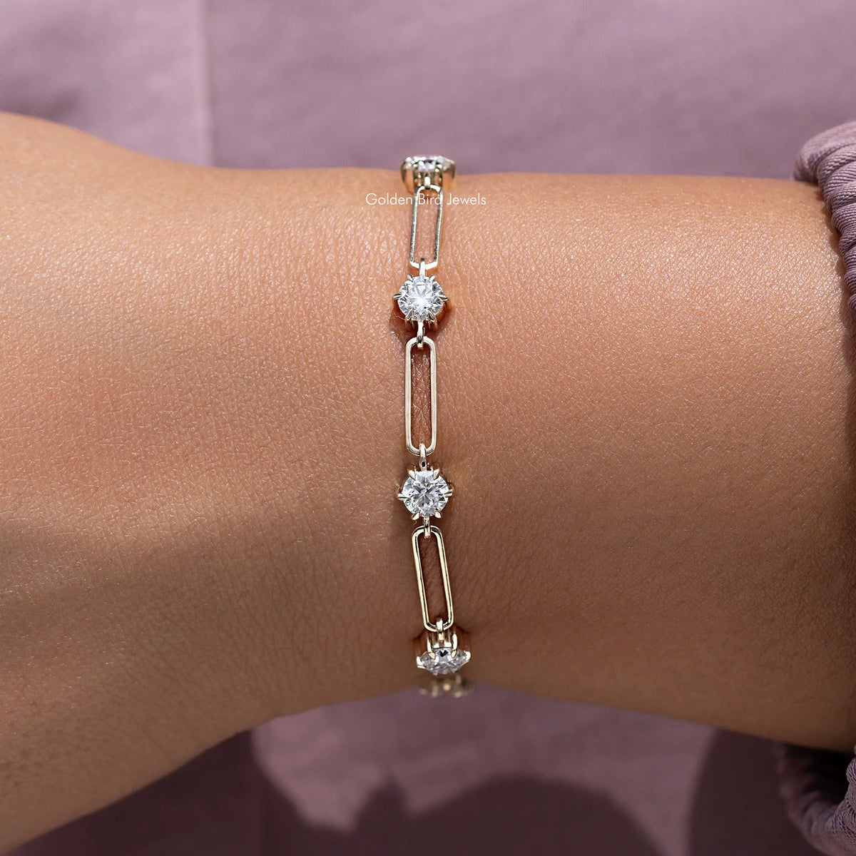 Gold-tone round-cut stone link bracelet with dangling sparkle on wrist