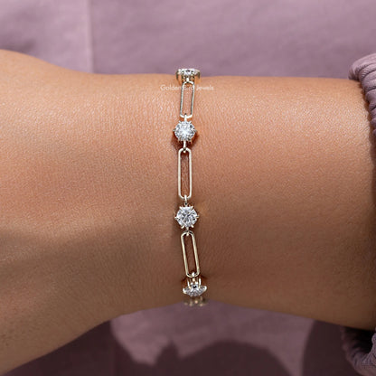 Gold-tone round-cut stone link bracelet with dangling sparkle on wrist