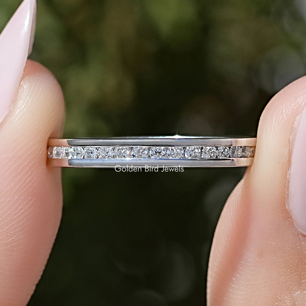 Close-up of silver-tone channel-set moissanite eternity band with round stone rows