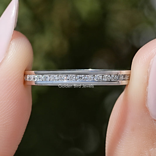 Close-up of silver-tone channel-set moissanite eternity band with round stone rows