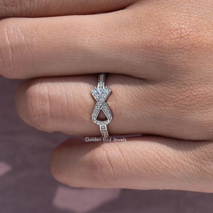 Ribbon-style moissanite ring with X ribbon motif and round-cut stones, silver tone