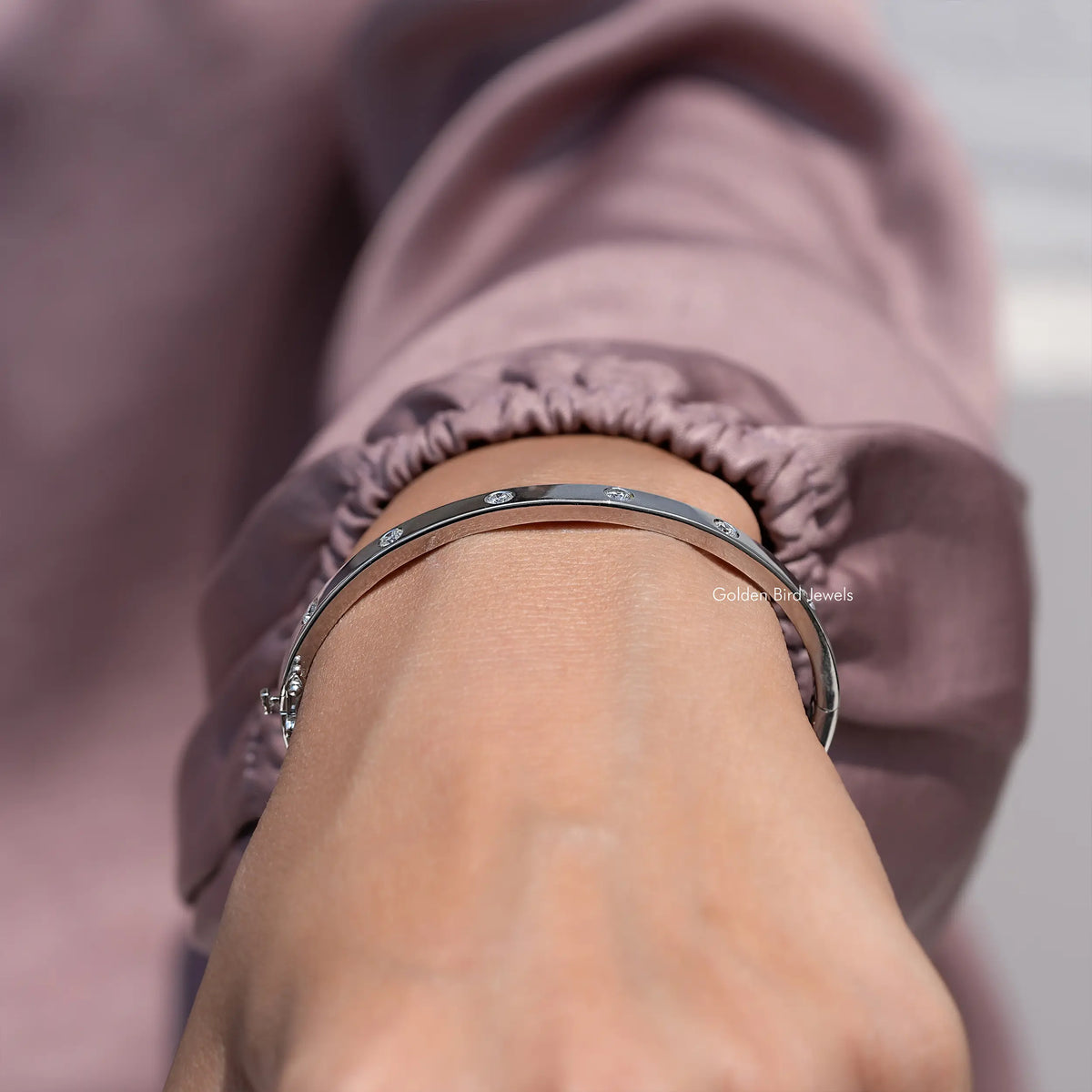 Wide silver diamond bangle with round flush-set stones, viewed from above