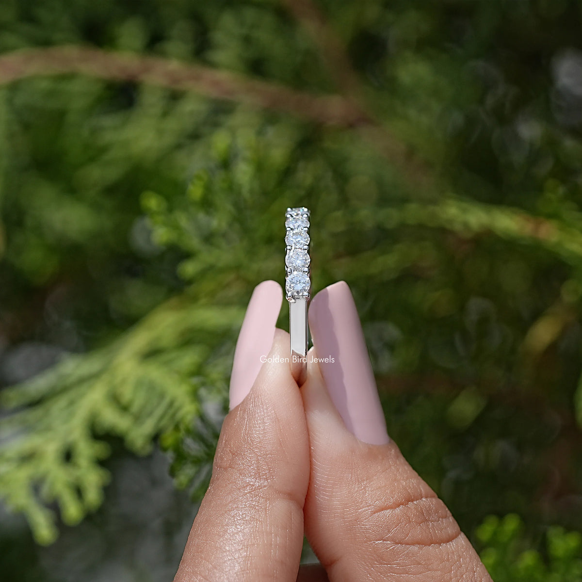 Vertical view of half eternity moissanite band with clear round-cut stones