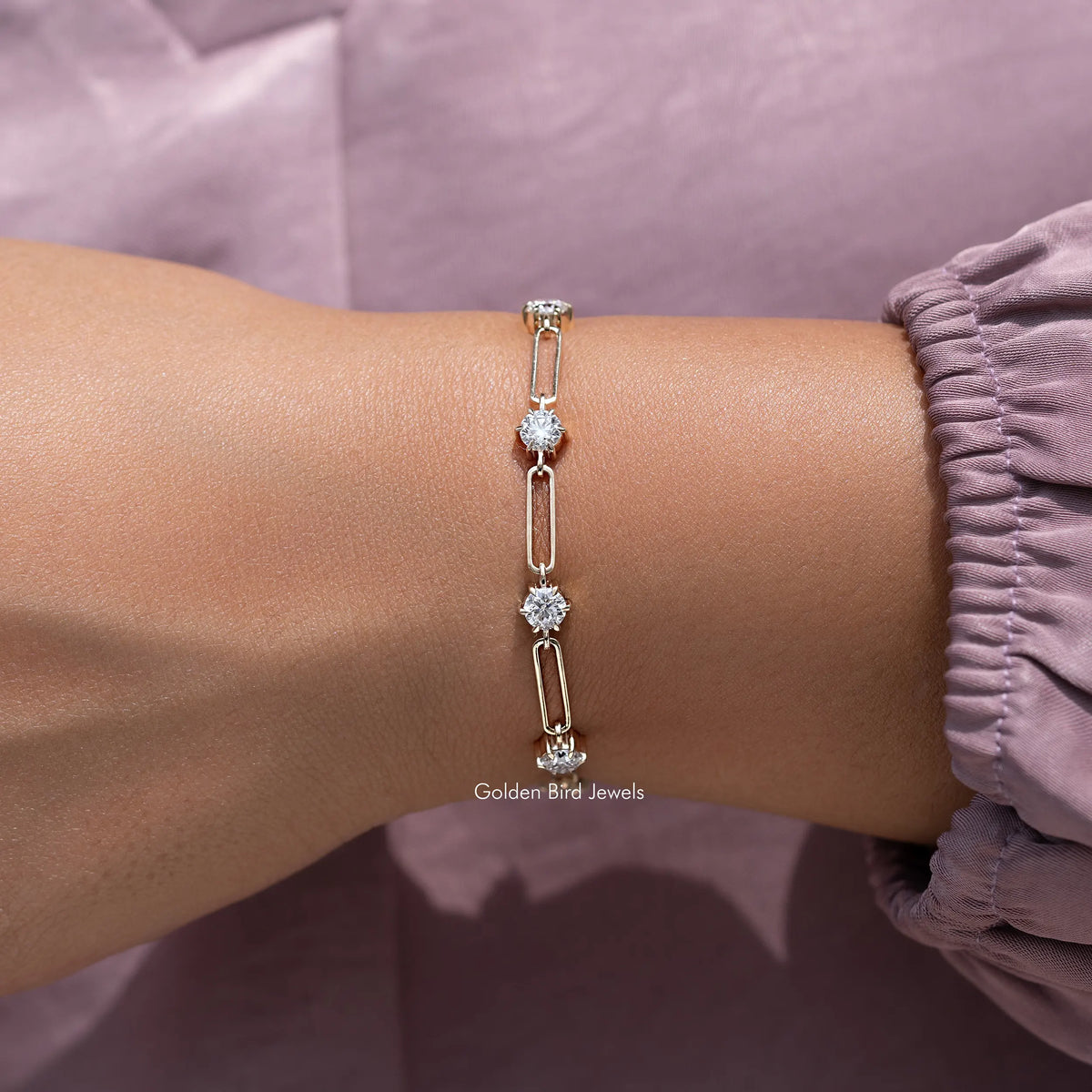Gold-tone round-cut stone link bracelet on wrist with multiple sparkle stations