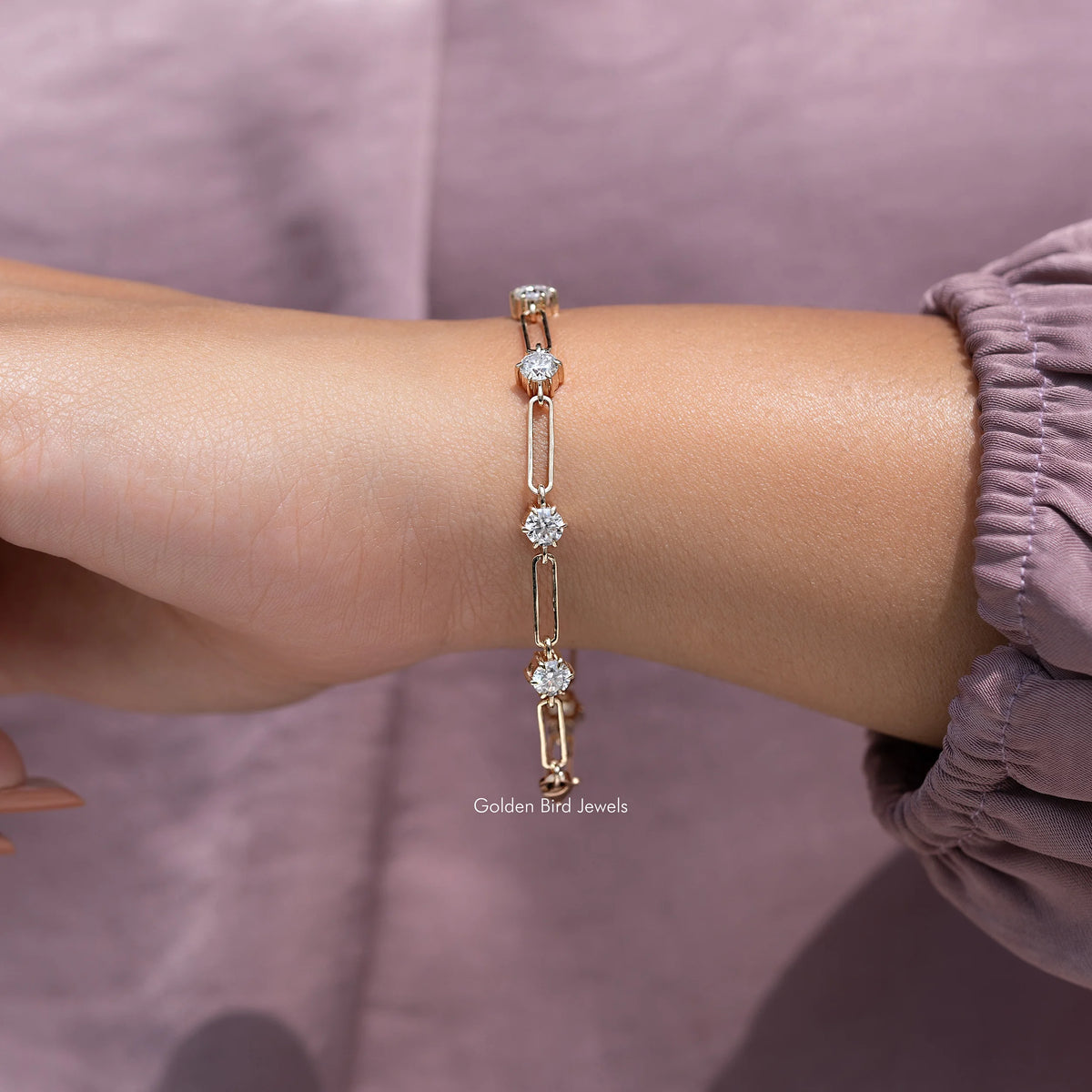 Gold-tone moissanite link bracelet with round-cut stones on wrist