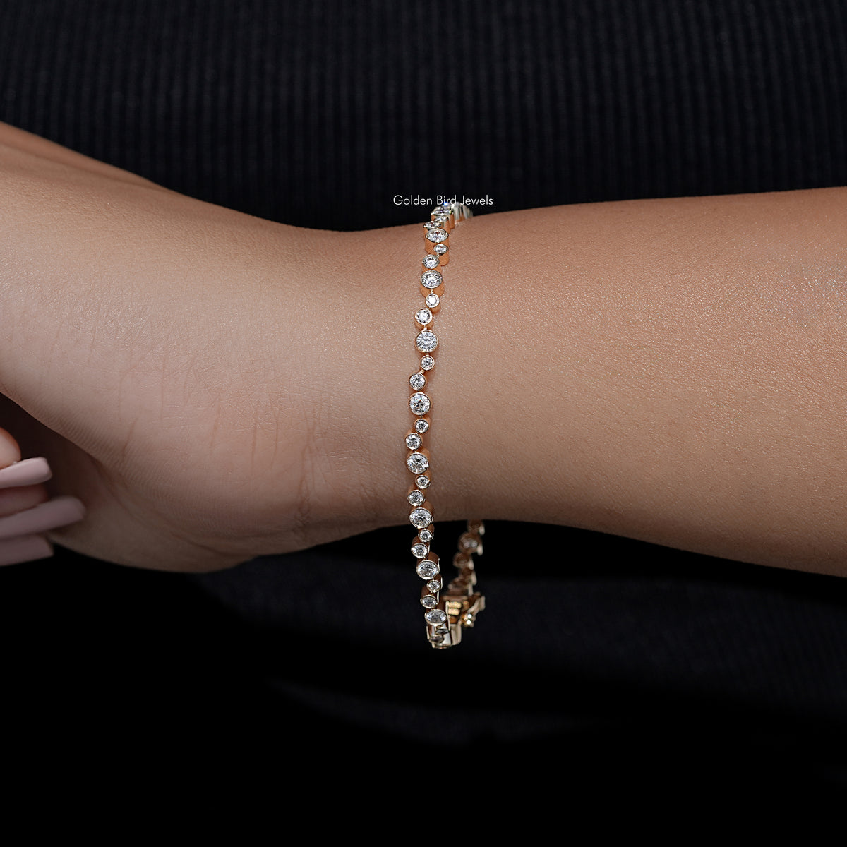 Gold-tone bezel-set round lab diamond tennis bracelet on wrist