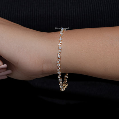 Gold-tone bezel-set round lab diamond tennis bracelet on wrist