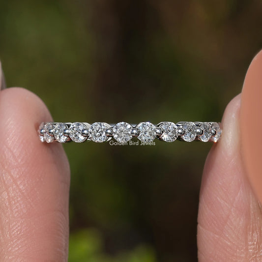 Silver-tone half eternity band with row of round moissanite stones, close-up
