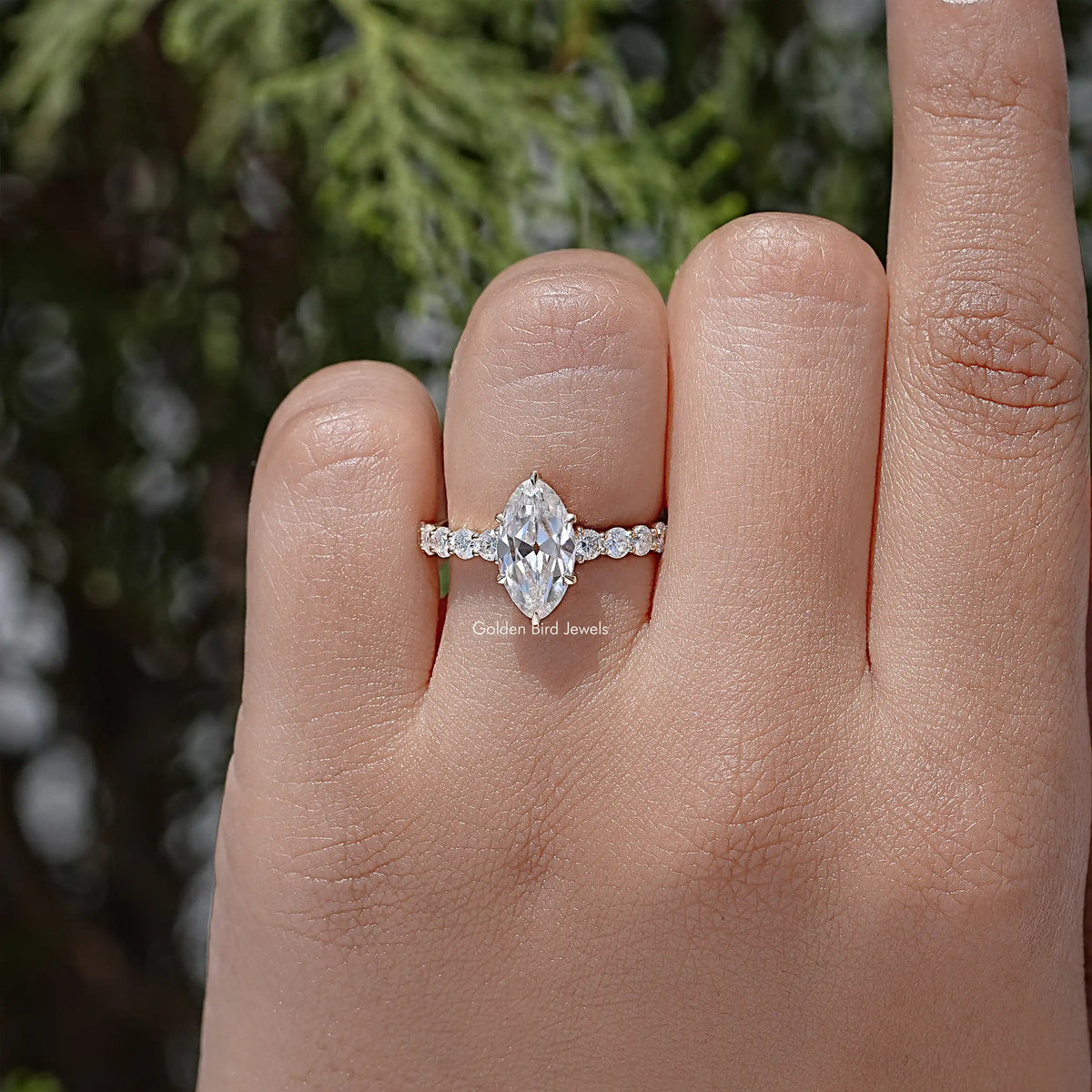Moissanite ring with oval-cut center stone and small accent stones on a slim band